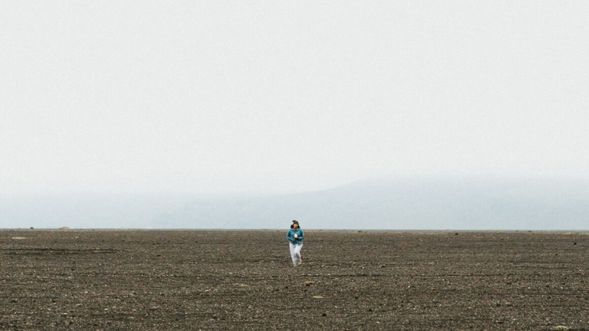 Woman walking across barren land