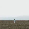 Woman walking across barren land