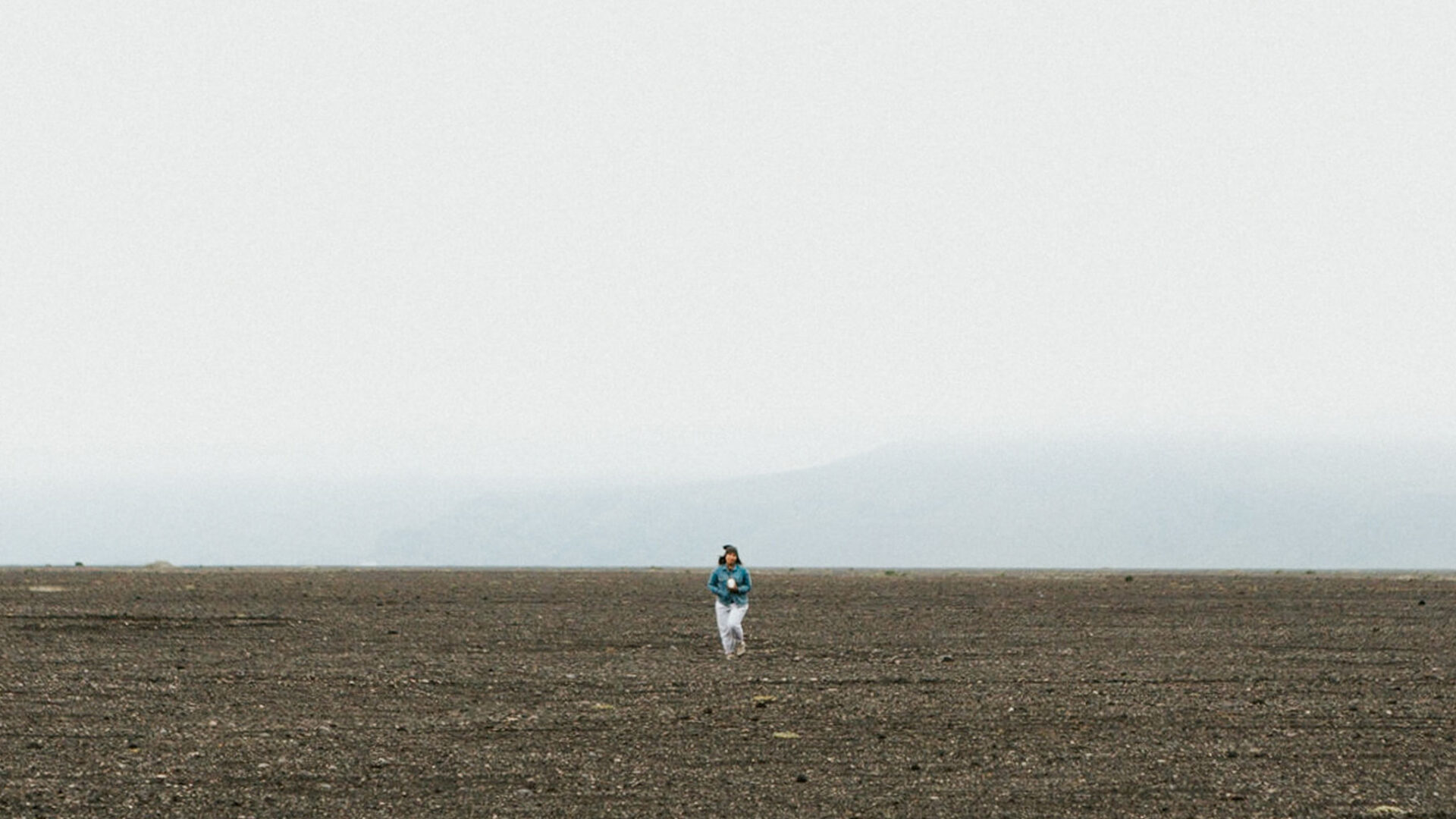 Woman walking across barren land