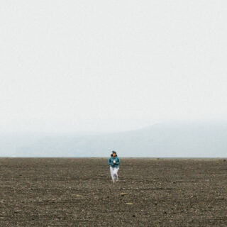 Woman walking across barren land