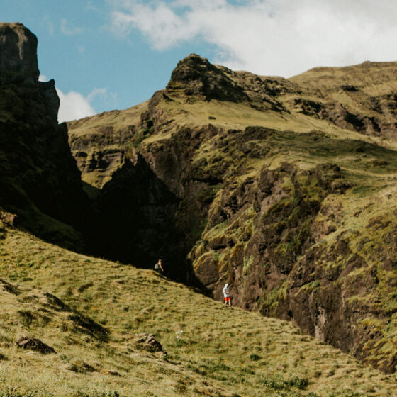Two people hiking down a large mountain