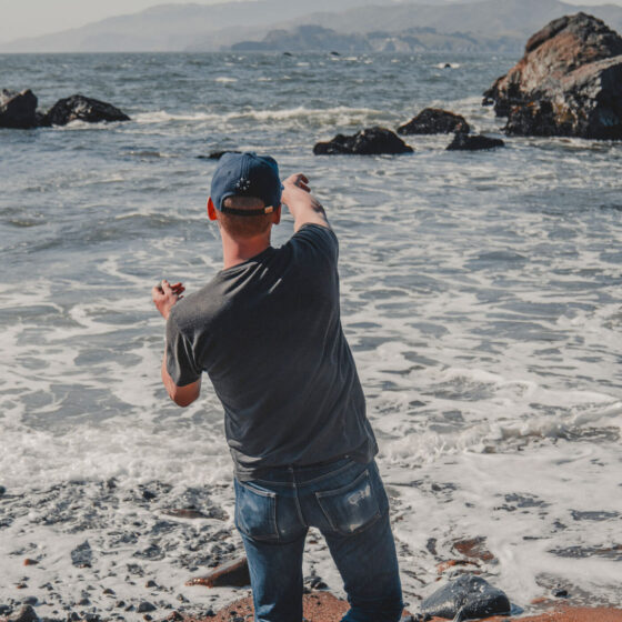 Man thowing rocks into water