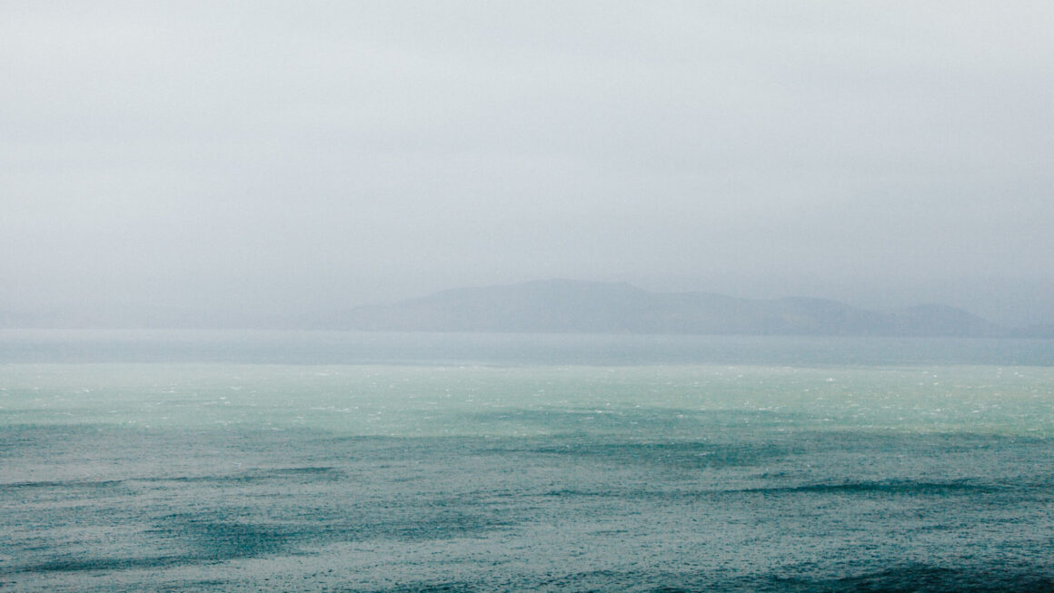 Rain coming down on large body of water