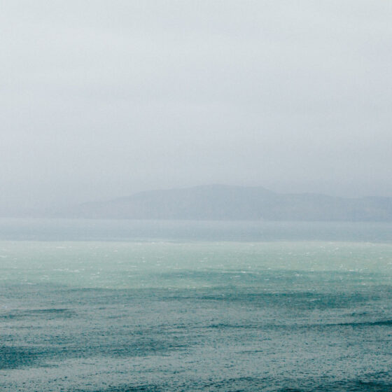 Rain coming down on large body of water