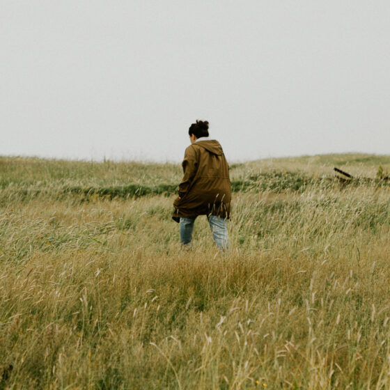Woman walking through tall grass