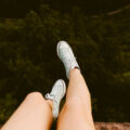 Girls legs and feet dangling over edge of a cliff