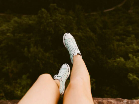 Girls legs and feet dangling over edge of a cliff