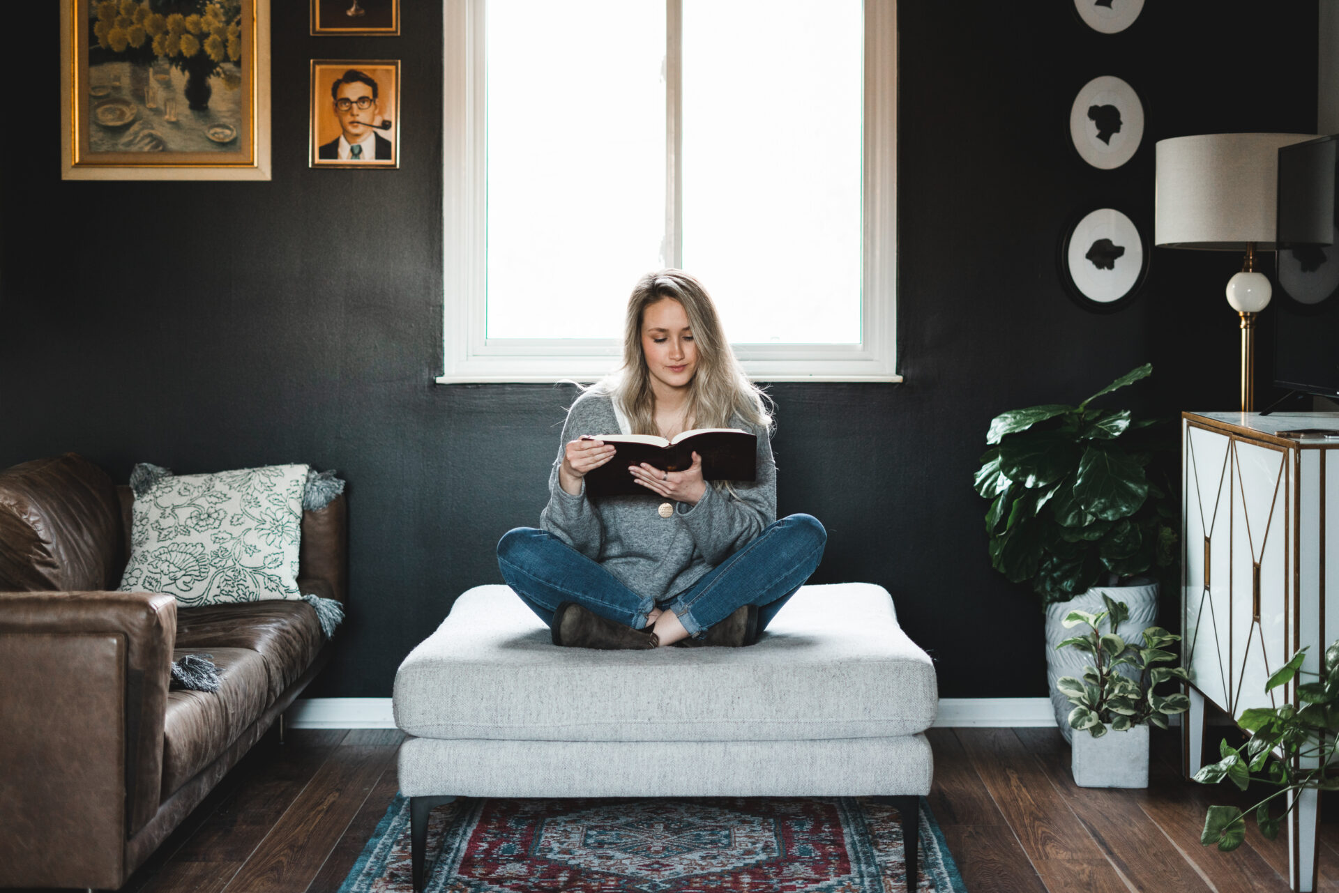 Girl reading the Bible on a couch ottoman